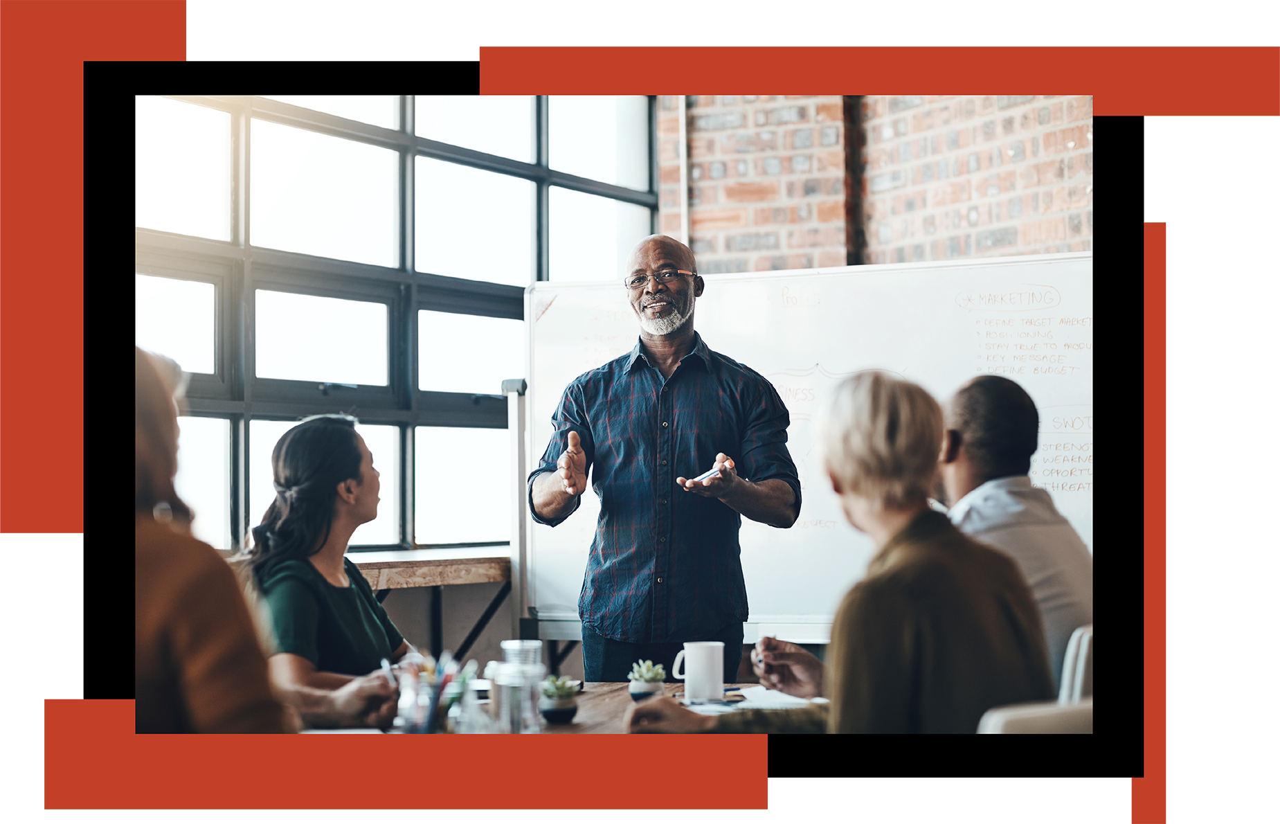 An African American man presenting to a group of people at a table
