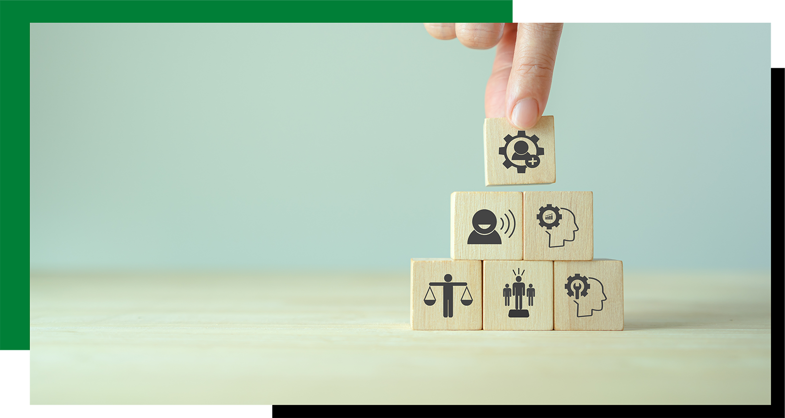 A hand stacking wooden blocks